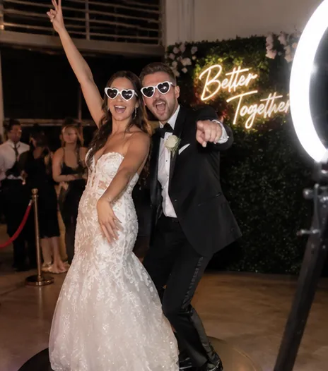 Bride and groom in heart sunglasses on a 360 photo booth