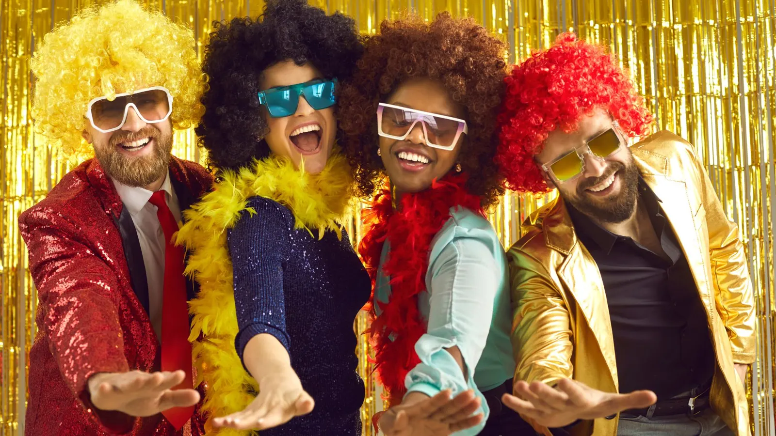 Friends in costume wigs and boas at a photo booth
