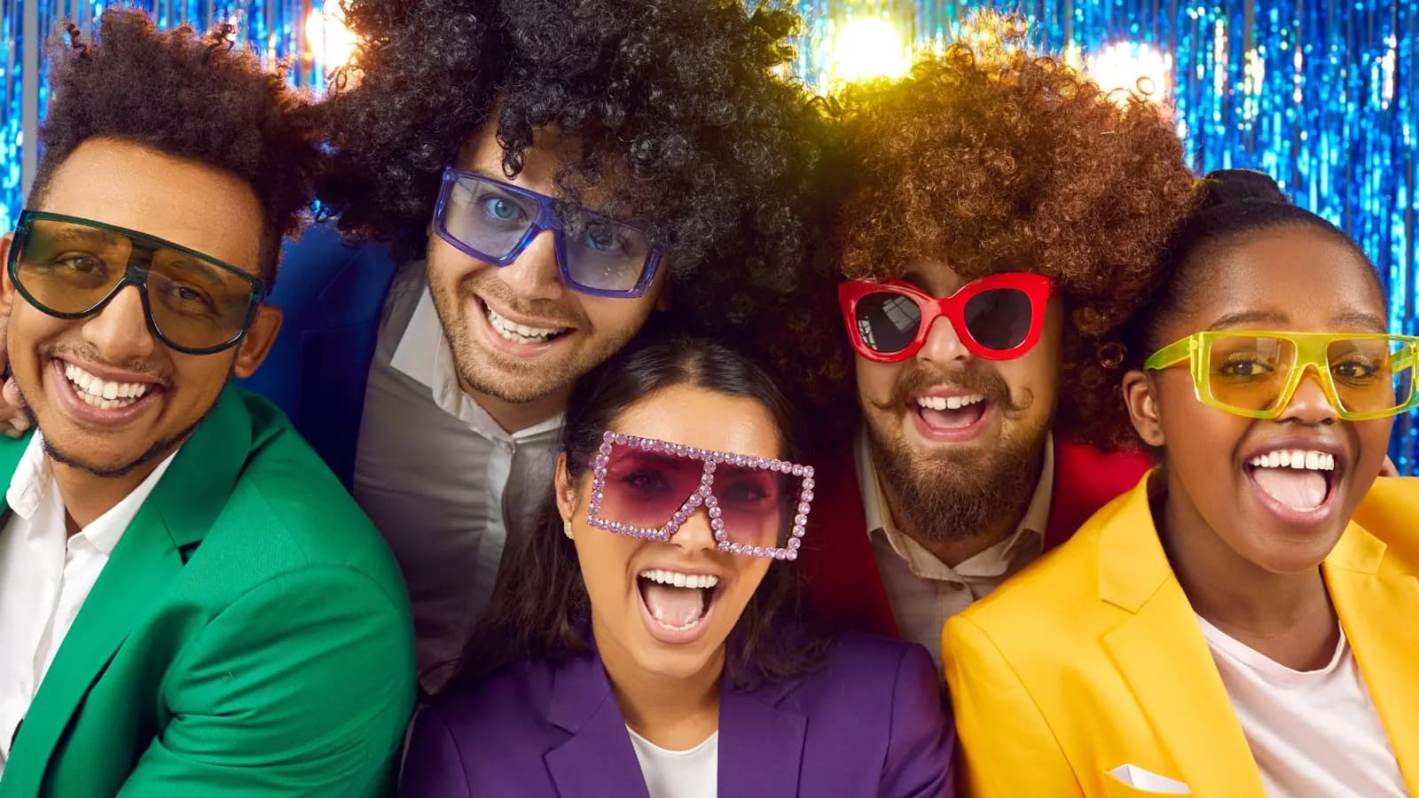Friends in oversized sunglasses at a photo booth backdrop