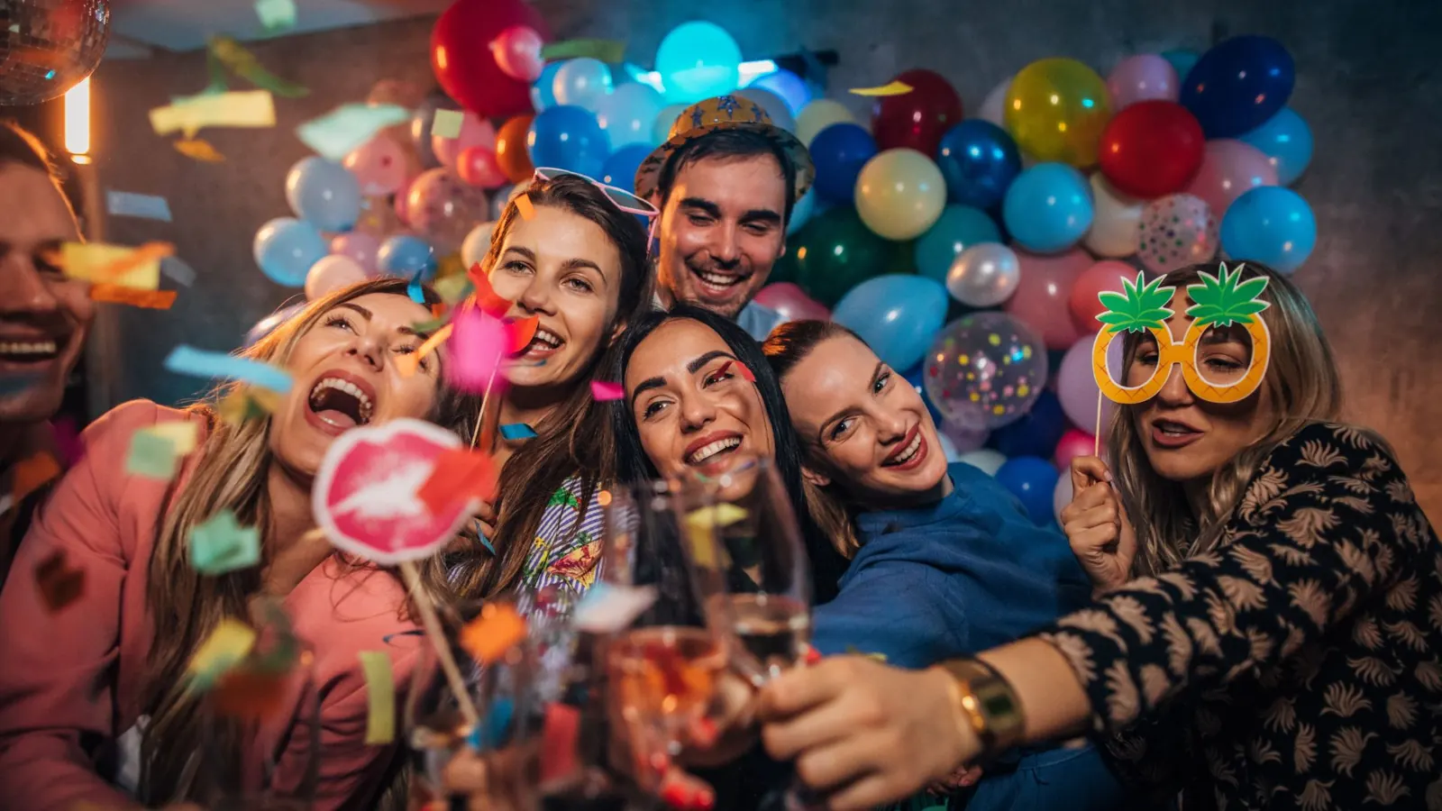Friends taking a selfie with photo booth props