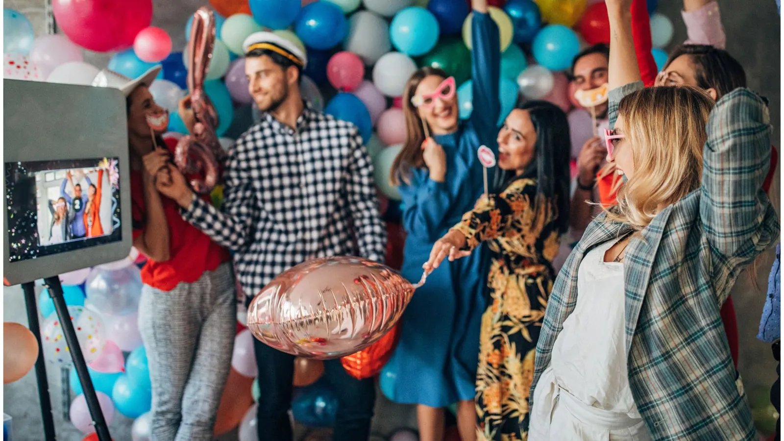 Guests dancing near a photo booth screen