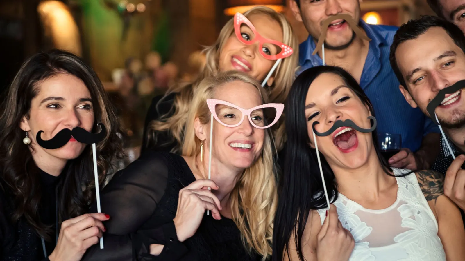 Guests posing with mustache and glasses props